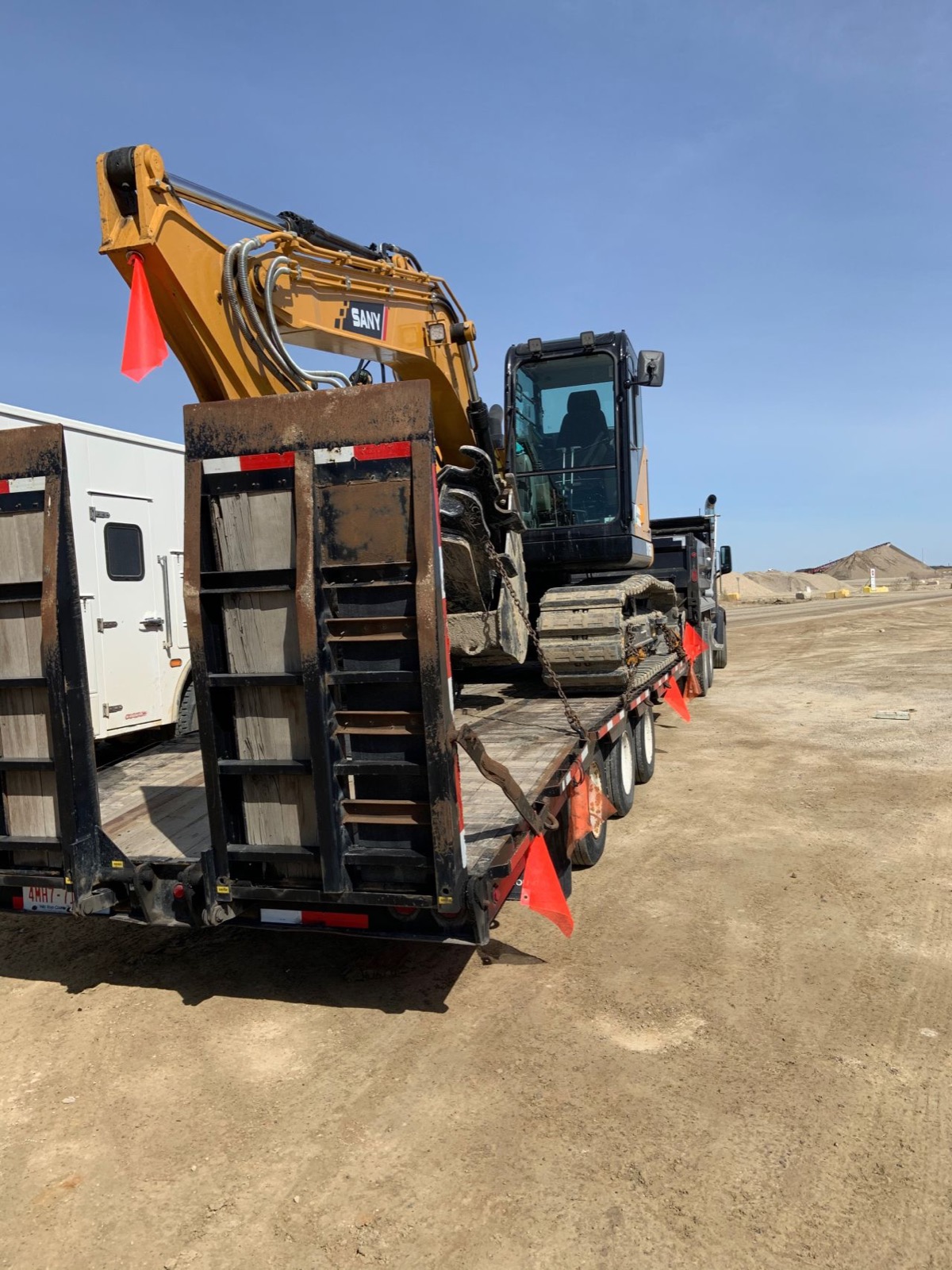 SANY excavator chained down on an A.F. Trucking step-deck trailer