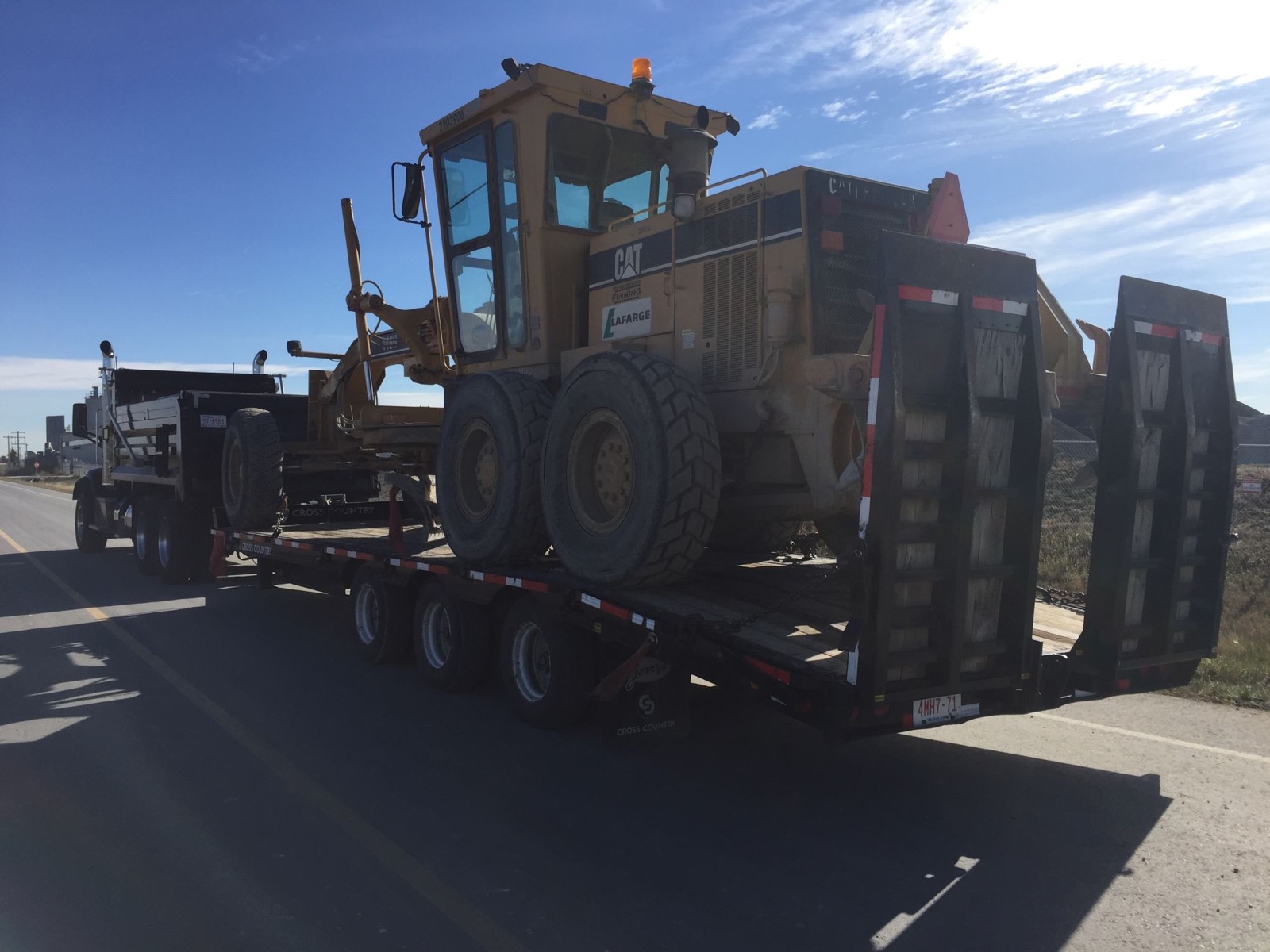 Caterpillar grader loaded on a step-deck trailer