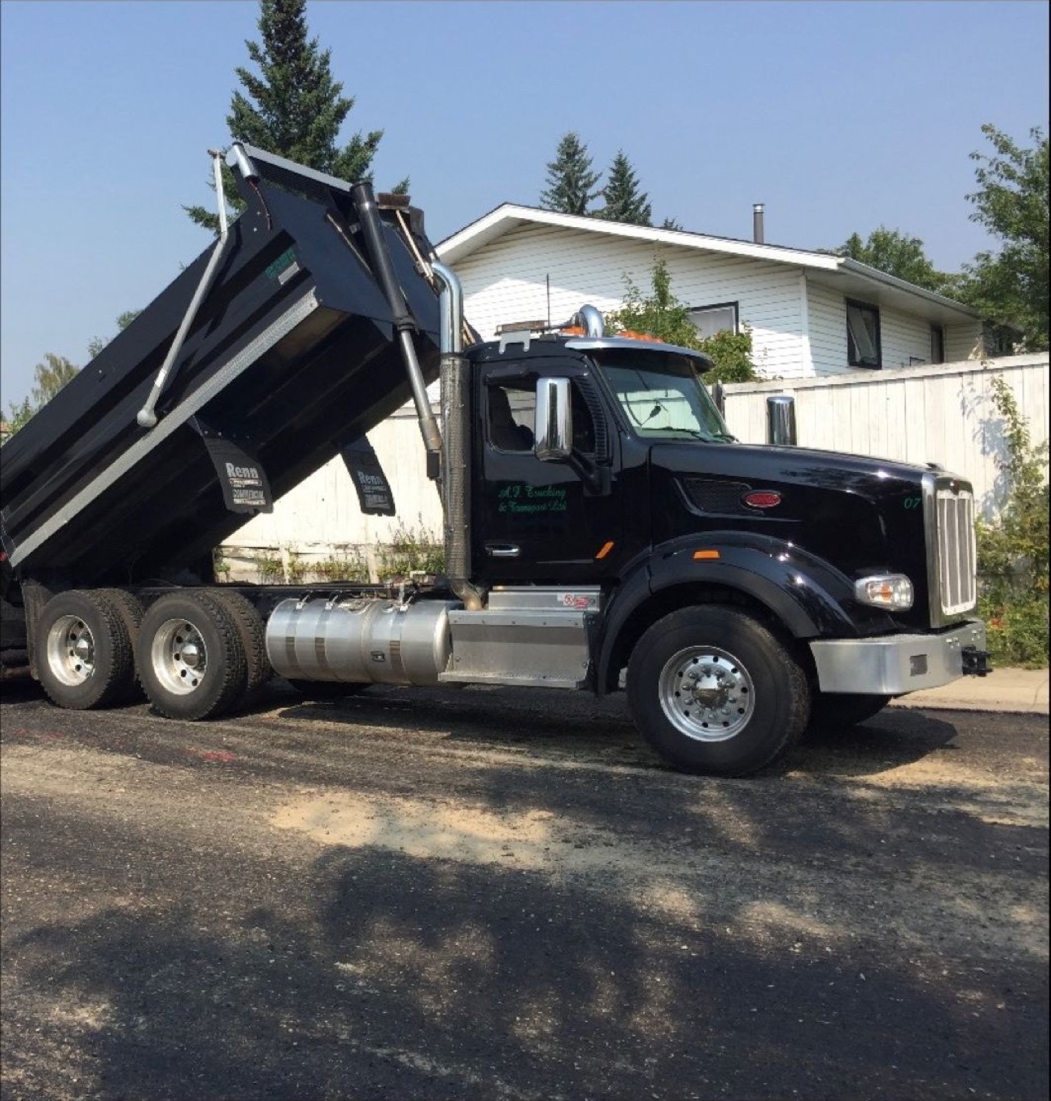 A.F. Trucking Peterbilt end dump with the box raised, tipping a load